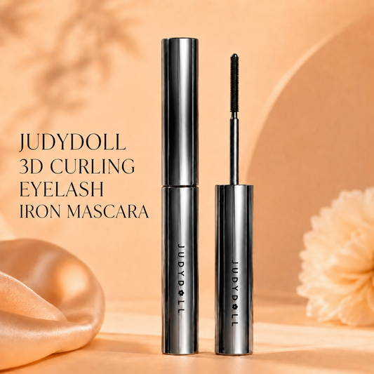 Judydoll 3D Curling Eyelash Iron Mascara with metallic silver tube and straight mascara wand on a warm peach beauty background.